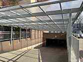 Überdachung aus glatten, transparenten Polycarbonatplatten auf Tragkonstruktion aus Stahlprofilen