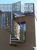 Wendeltreppe aus Stahl mit Geländer aus perforiertem Alublech