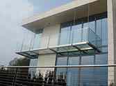 Balkon mit Tragkonstruktion aus Stahl, Glasbodenplatten und Ganzglasgeländer mit Edelstahlhandlauf