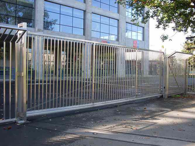 Freitragendes Schiebetor aus rostfreiem Stahl mit Staketenfüllung. Eingebaut Rollenmechanismus mit Kunststoffrollen und Schiebetorprofil mit Führungsstegen