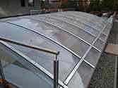 Überdachung der Tiefgarageneinfahrt aus glatten, transparenten Polycarbonatplatten montiert auf Stahlkonstruktion aus verzinkten, pulverbeschichteten Stahlprofilen