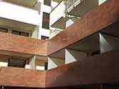Balkongeländer mit Füllung aus HPL-Laminat. Auf Balkonen Trennwände aus Milchglasscheibe eingebaut im Stahlrahmen