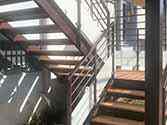 Stahltreppe, Stufen aus Holzbohlen und Geländer mit Glasfüllung