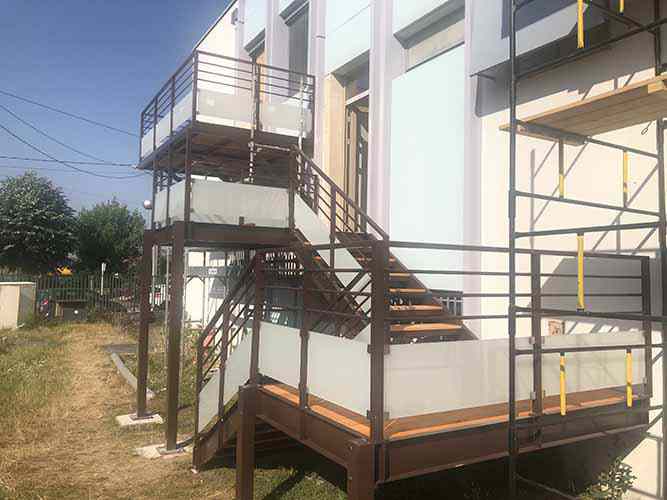 Außentreppe und Balkon mit Stahltragkonstruktionen, Holzbohlen und Geländer mit Glasfüllung